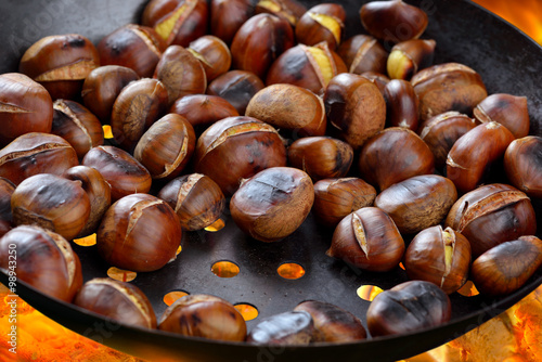 Fotomural Maroni beim Rösten in der Maronipfanne über offenem Feuer