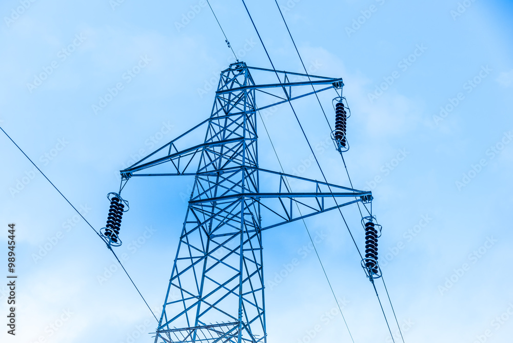 Sun setting behind a row of electricity pylons Sun setting behind a row of electricity pylons