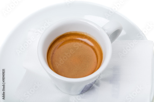 Full espresso cup on plate.