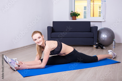 beautiful flexible woman doing stretching exercise on yoga mat a