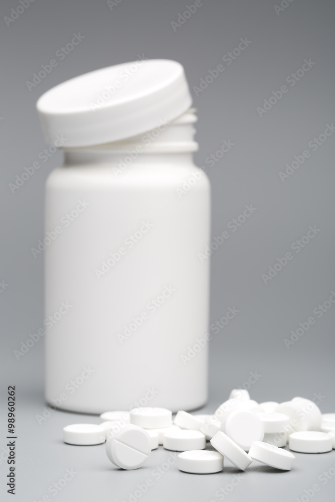 Round white tablet with the pill bottle Round white tablet with the pill bottle