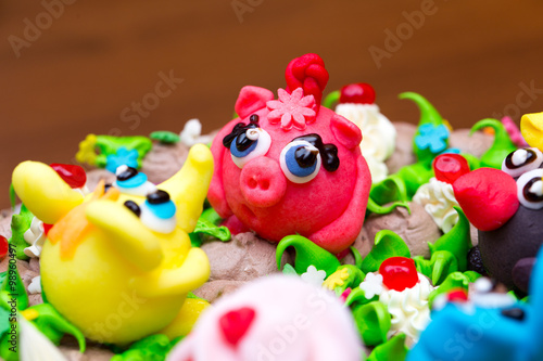 Celebration colorful cake decorated with fruit, chocolate and figures of animals for kids party