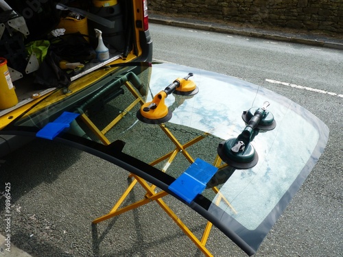 replacing the defective windshield of a car affixed with vacuum suckers