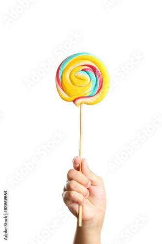 Child's hand holding lollipop candy on stick