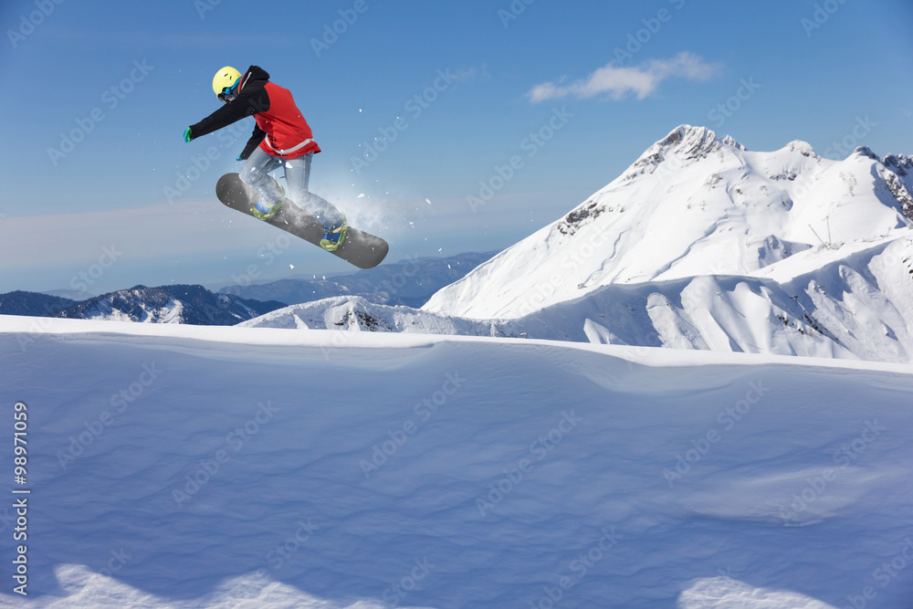 Flying snowboarder on mountains. Extreme sport.