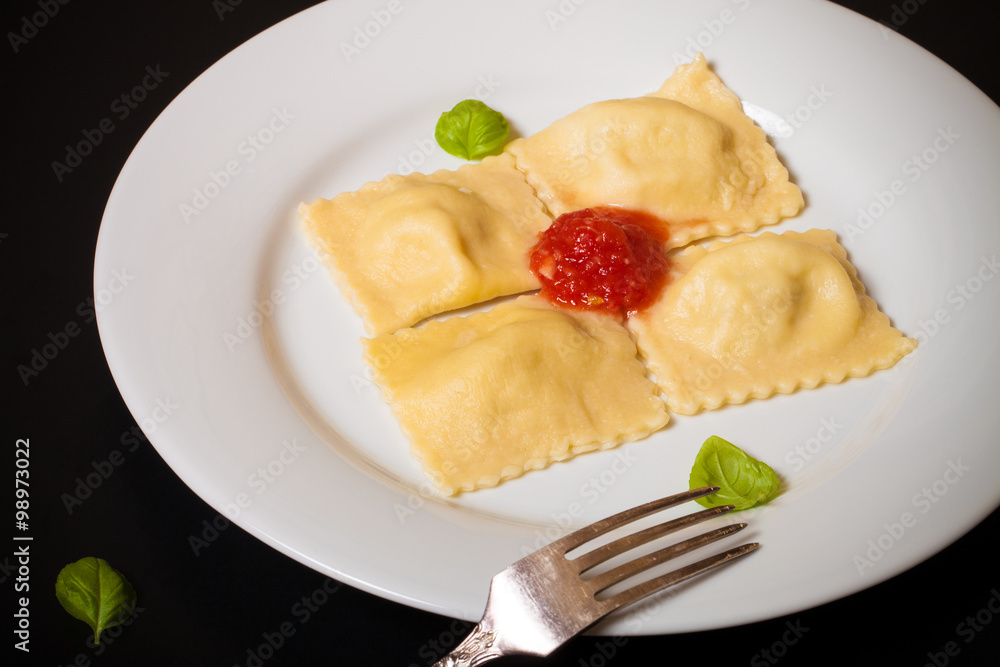 Russian ravioli - pelmeni with tomato sauce and basil on a white Russian ravioli - pelmeni with tomato sauce and basil on a white