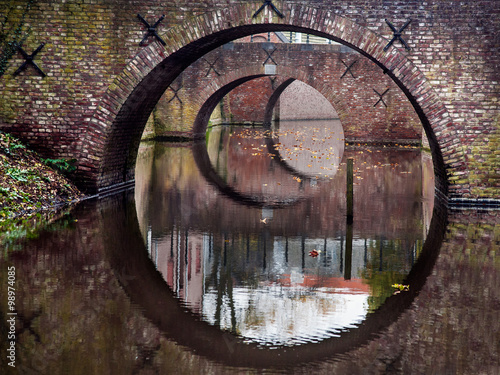 Reflection of three bridges in water of a canal in Den Bosch, The Netherlands