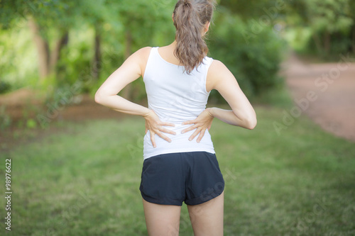 Junge Sportlerin mit Rückenschmerzen