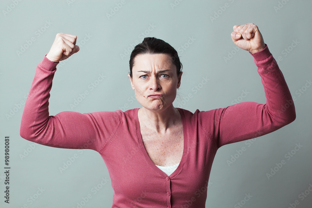Φωτογραφία muscle concept - angry 40s woman flexing her muscles up for metaphor of female f