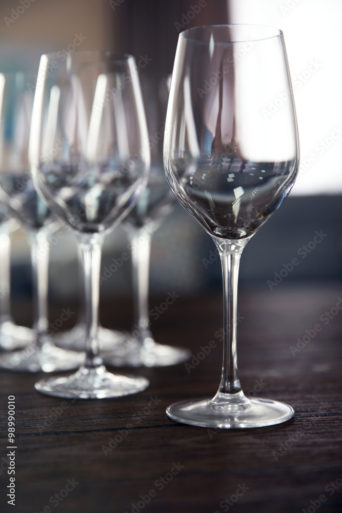 Empty wine glasses on wooden table against blurred background Empty wine glasses on wooden table against blurred background