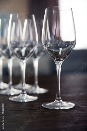 Empty wine glasses on wooden table against blurred background