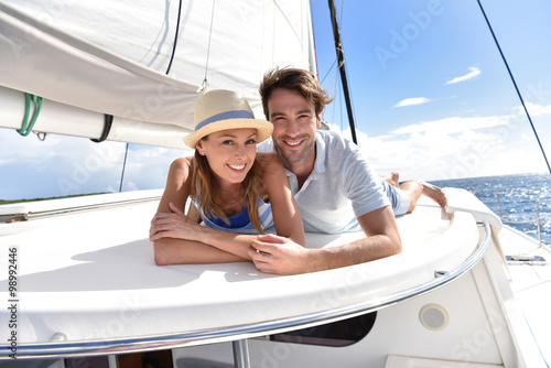 Couple laying on a sailboat deck during cruise © goodluz
