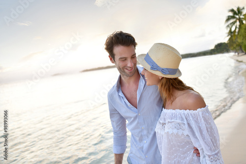 Happy just married couple walking on a sandy beach