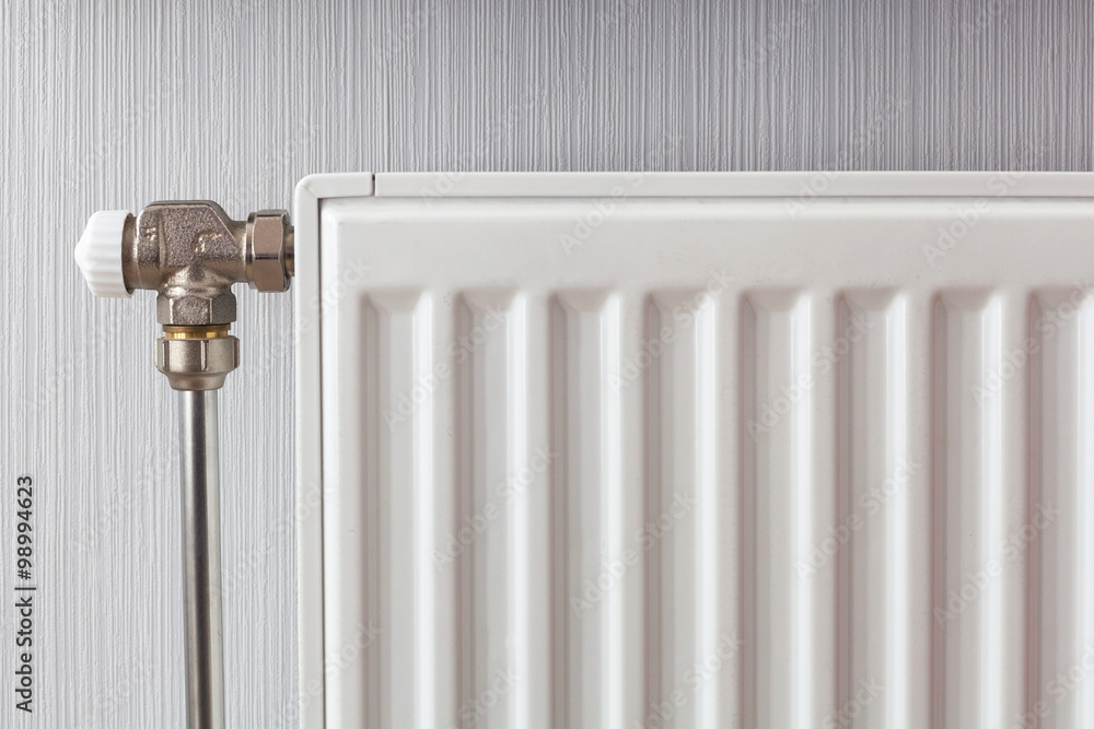 Heating white radiator with adjuster of warming in living room. Heating white radiator with adjuster of warming in living room.