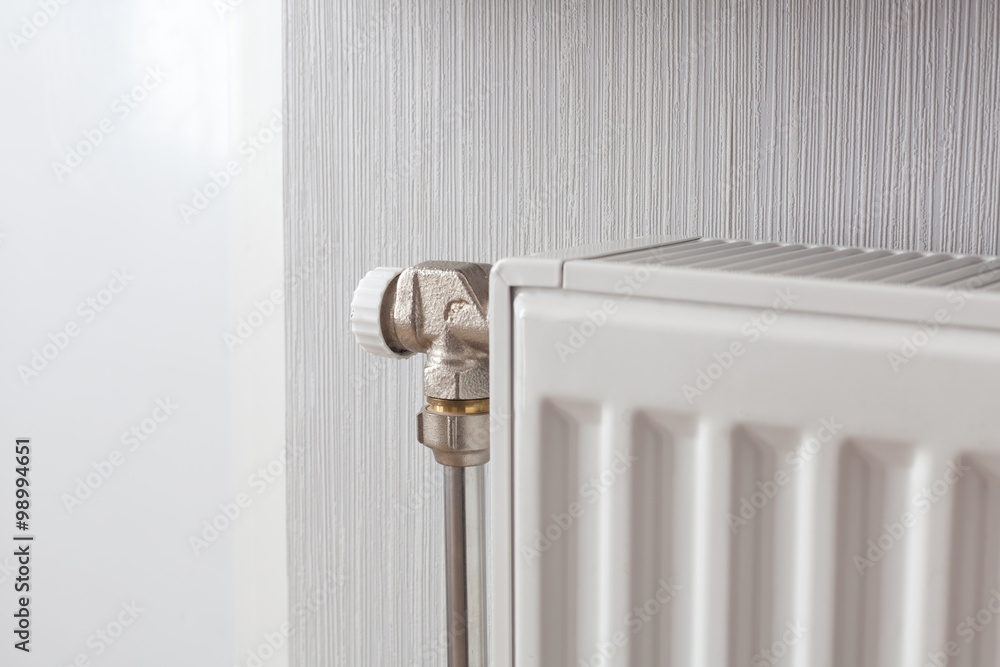 Heating white radiator with adjuster of warming in living room. Heating white radiator with adjuster of warming in living room.
