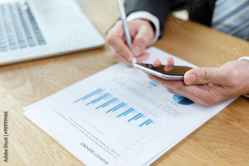 businessman checking financial reports on table