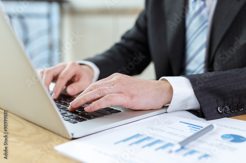 businessman checking financial reports on table