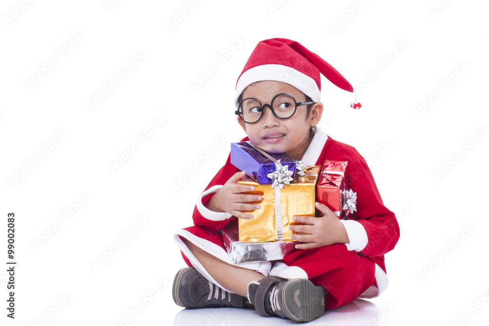 Little boy wearing Santa Claus uniform with gifts Little boy wearing Santa Claus uniform with gifts