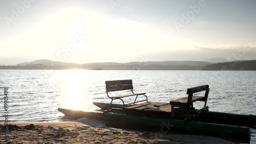 Abandoned old rusty paddle boat stuck on sand of beach. Wavy water level, island on horizon. Autumn weather at coastline  photo