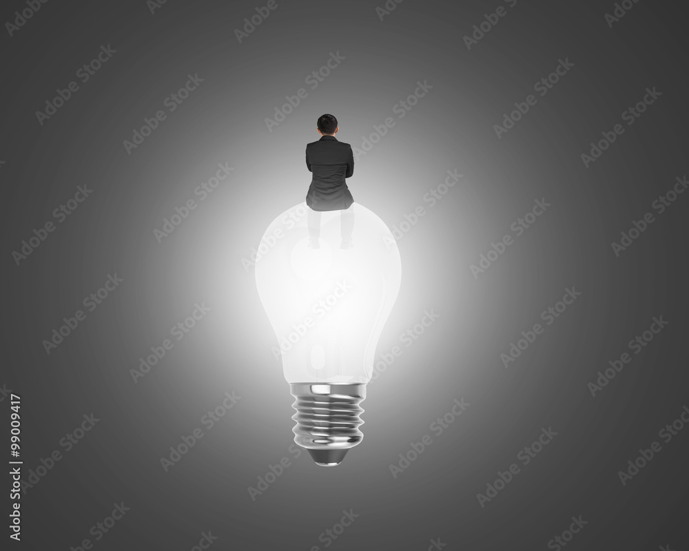Fotografie Businessman sitting on light bulb