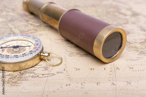 Fotografie Old compass and old telescope on vintage map world explorer concept