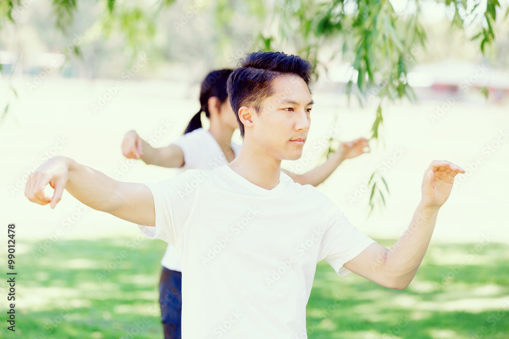 People practicing thai chi in park People practicing thai chi in park