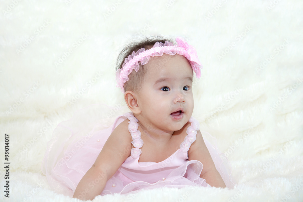 Cute five months asian baby laughing with pink dress., on bright soft carpet. Cute five months asian baby laughing with pink dress., on bright soft carpet.