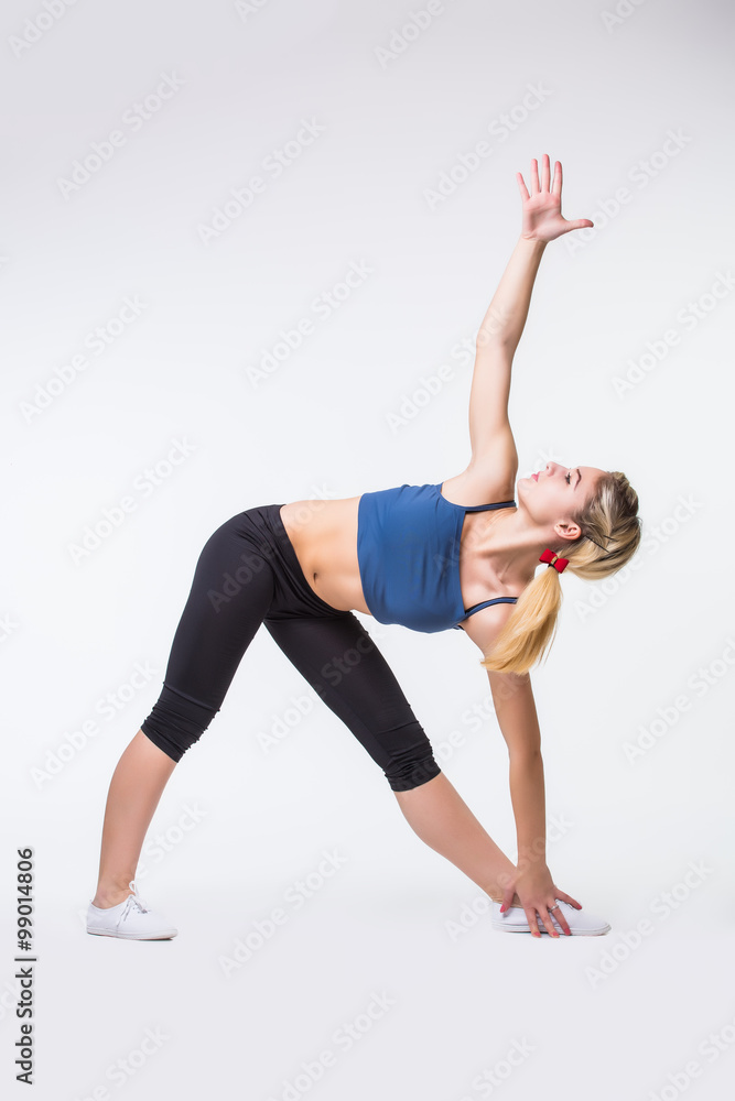 Attractive fit woman exercising in studio with copyspace. Image of healthy young female athlete doing fitness workout against grey background with poor light Attractive fit woman exercising in studio with copyspace. Image of healthy young female athlete doing fitness workout against grey background with poor light