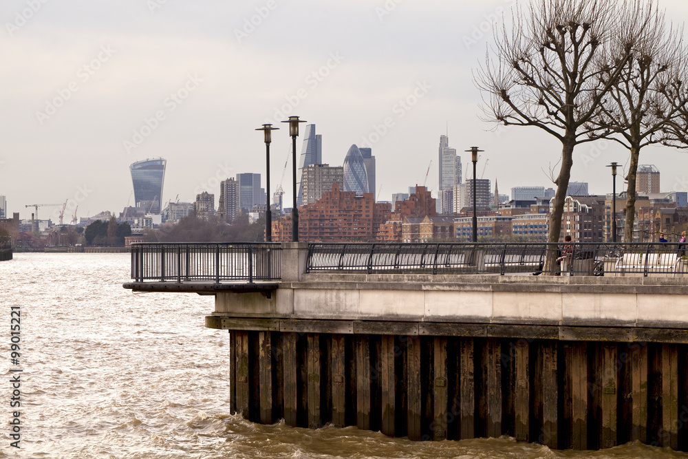 A lookout on the Thames Path, a walk along the river Thames in London. The view is of the London financial skyline and a bend in the river.