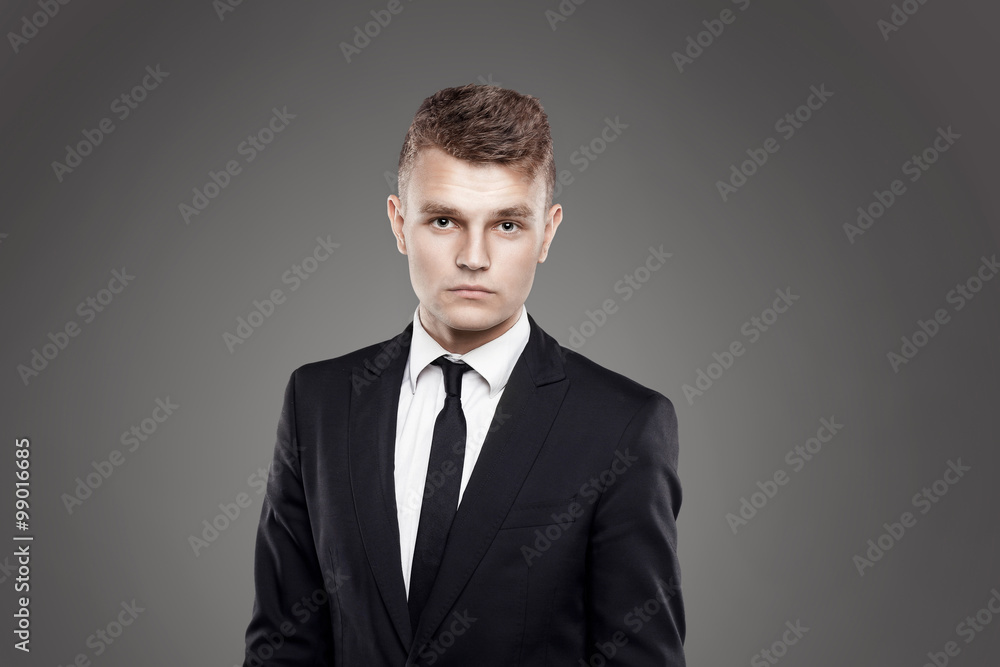 Portrait of young trendy groom with black tie on gray background Portrait of young trendy groom with black tie on gray background