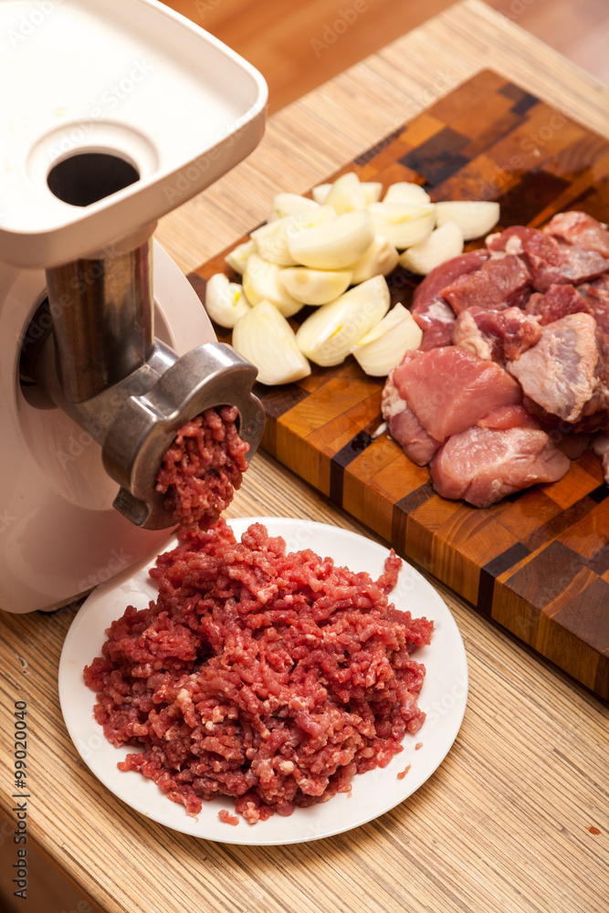 The electric meat grinder, forcemeat, onions and the cut meat The electric meat grinder, forcemeat, onions and the cut meat