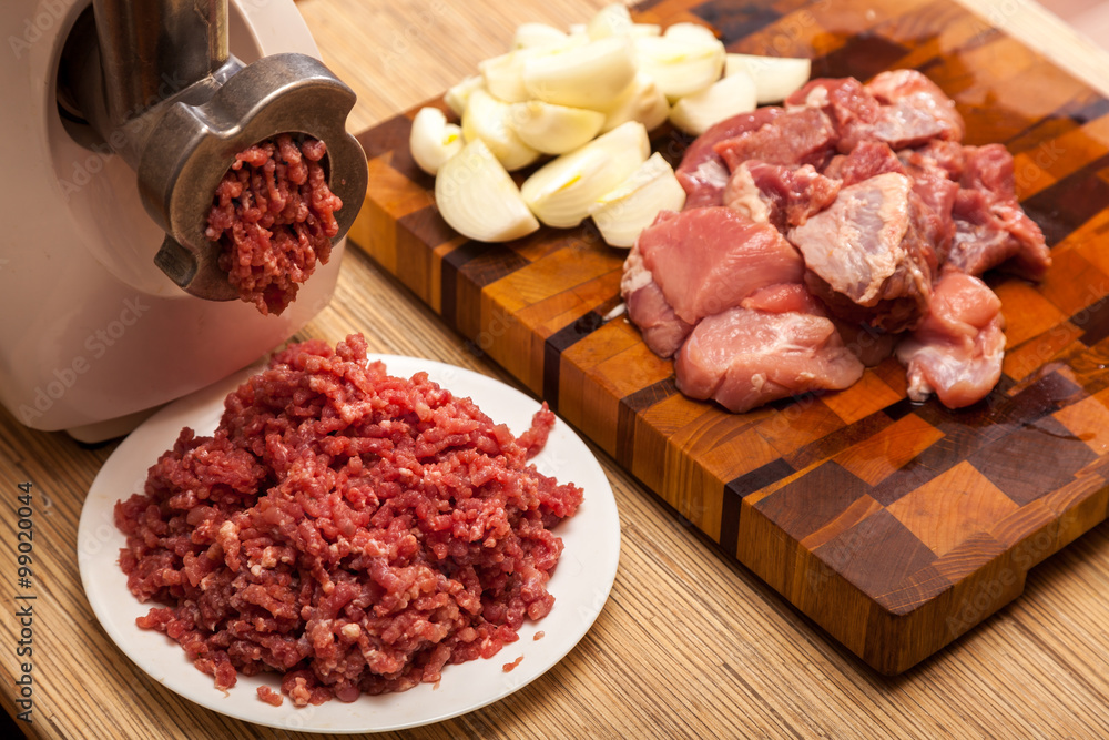 The electric meat grinder, forcemeat, onions and the cut meat The electric meat grinder, forcemeat, onions and the cut meat