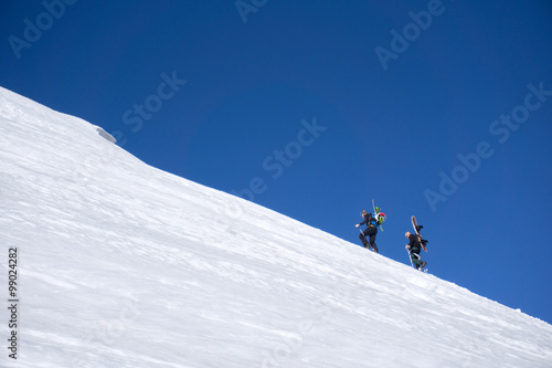 Snowboarders walking uphill for freeride