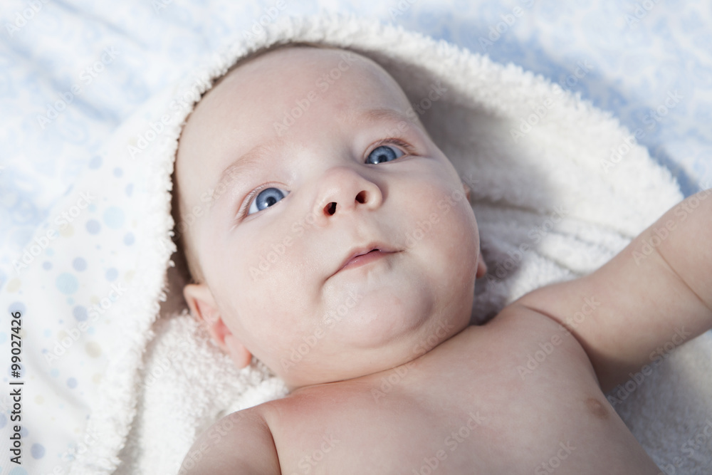 Happy baby boy wrapped bath towel after bath in bed at home Happy baby boy wrapped bath towel after bath in bed at home