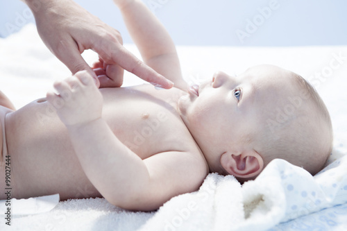 Mother applying cream over baby boy photo