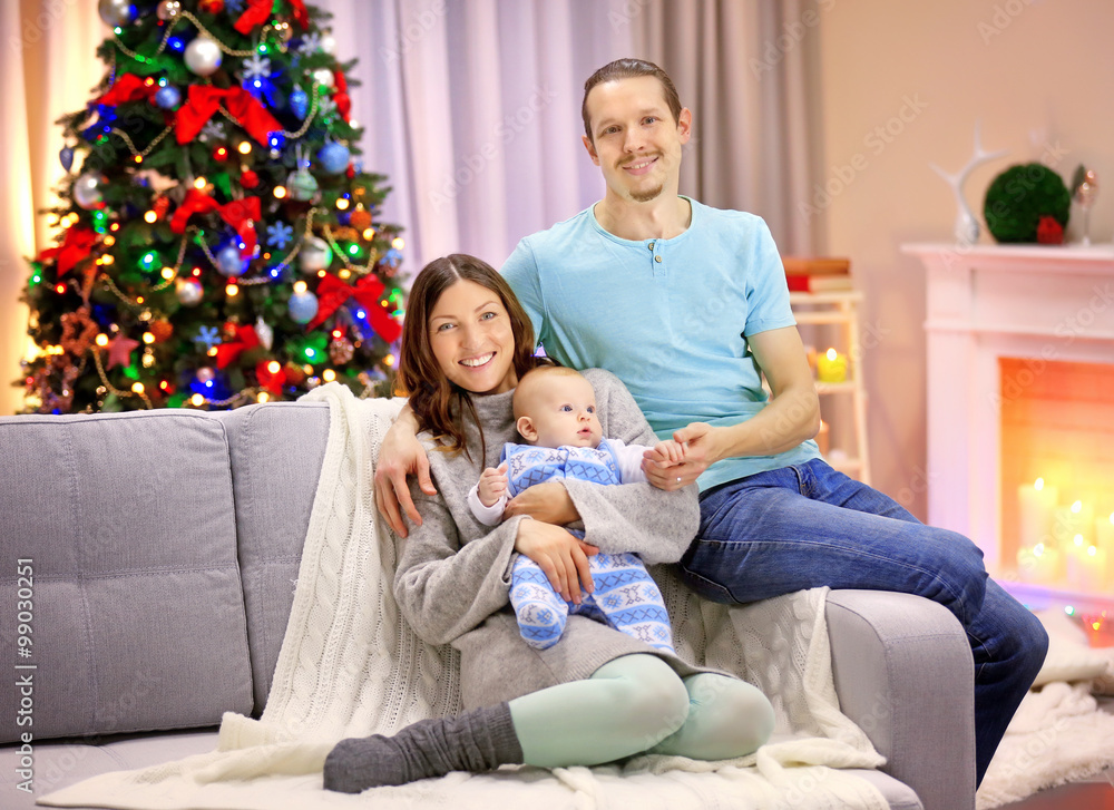 Happy family on sofa in the decorated Christmas room Happy family on sofa in the decorated Christmas room