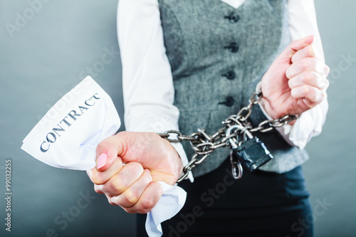 businesswoman with chained hands holding contract