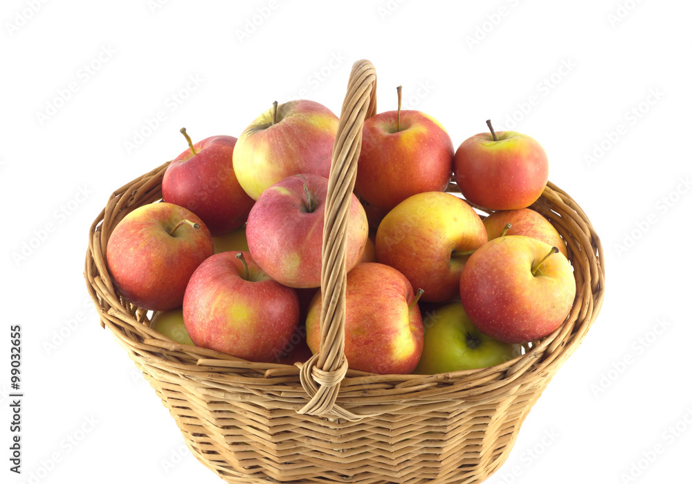 Brown wicker basket full of ripe selected apples isolated on white closeup Brown wicker basket full of ripe selected apples isolated on white closeup