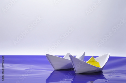 Two White Paper Boats on a blue and white background  