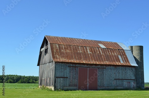 Old vintage barn with a rusted tin roof on a sunny summer day