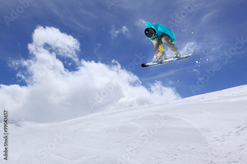 Flying snowboarder on mountains. Extreme sport.