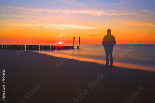 Картината върху платно Transparent ghost watching a beautiful sunset with break water on background, co