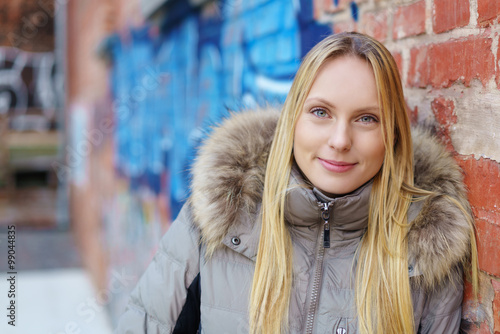 frau lehnt an einer wand mit grafitti