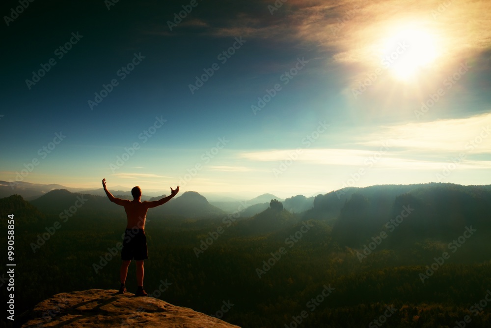 Climber in black pants. Gesture of triumph. Body naked man on the peak of sandstone rock in national park Saxony Switzerland Climber in black pants. Gesture of triumph. Body naked man on the peak of sandstone rock in national park Saxony Switzerland