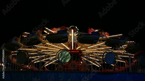 Ferry wheel rotating in fun park at night time
