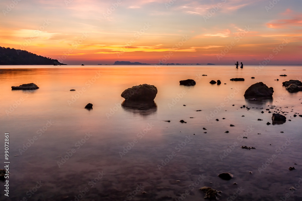 Sunset over sea and stones over tropical island Sunset over sea and stones over tropical island