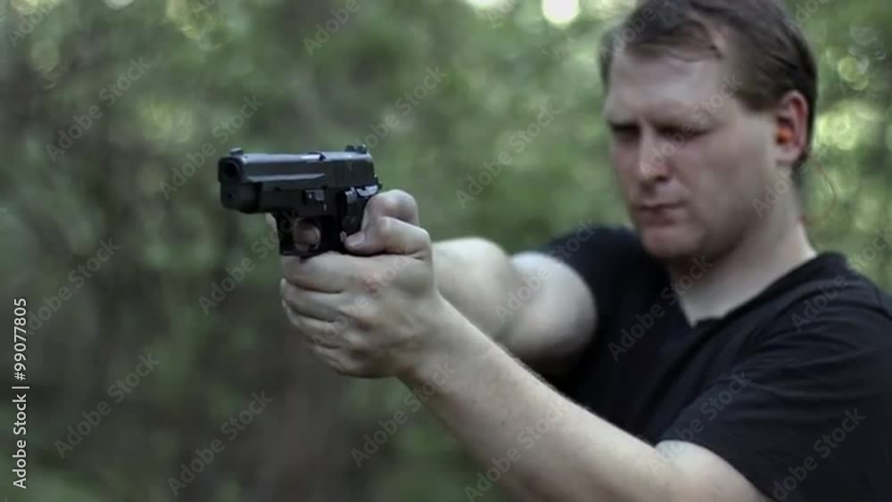 Close, frontal view of man firing a .44 caliber pistol in woodland. Muzzle flashes visible. Recorded in 4K, Ultra High Definition. Close, frontal view of man firing a .44 caliber pistol in woodland. Muzzle flashes visible. Recorded in 4K, Ultra High Definition.