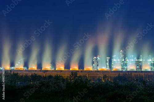 Steaming cooling tower of oil refinery plant.