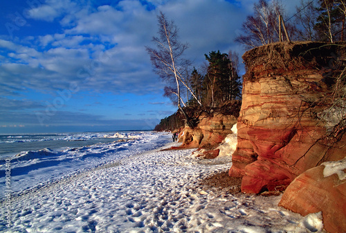 Coast of Baltic sea in Latvia. Frozen seacoast in the winter. Red sandstone cliffs at the sea.