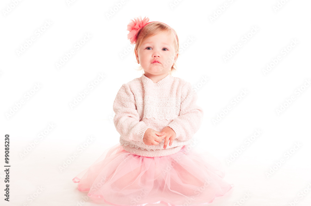 Cute baby girl 1-2 year old sitting on floor over white. Looking at camera. Childhood. Cute baby girl 1-2 year old sitting on floor over white. Looking at camera. Childhood.